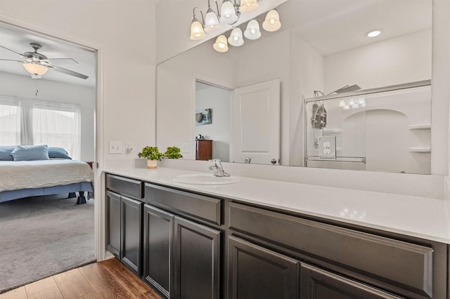 ensuite bathroom with ceiling fan, wood finished floors, ensuite bath, and vanity