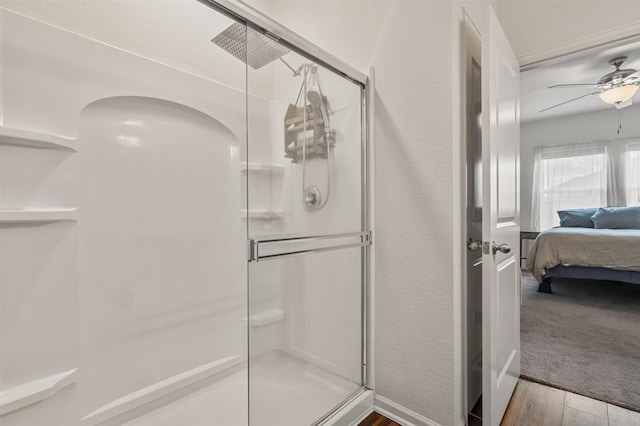 full bath with a shower stall, ceiling fan, wood finished floors, and ensuite bathroom