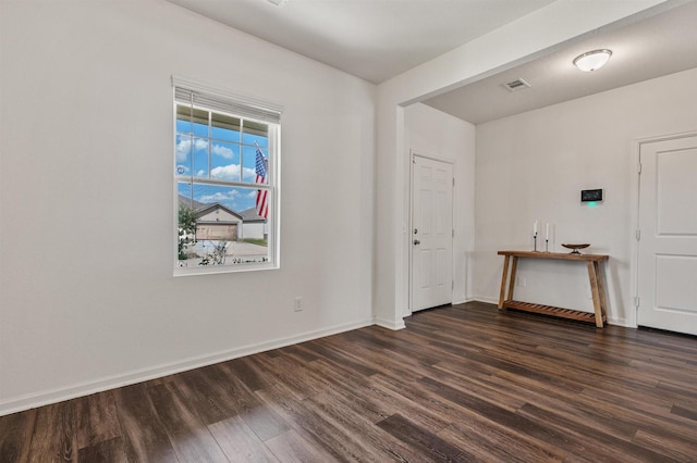 spare room featuring visible vents, baseboards, and wood finished floors