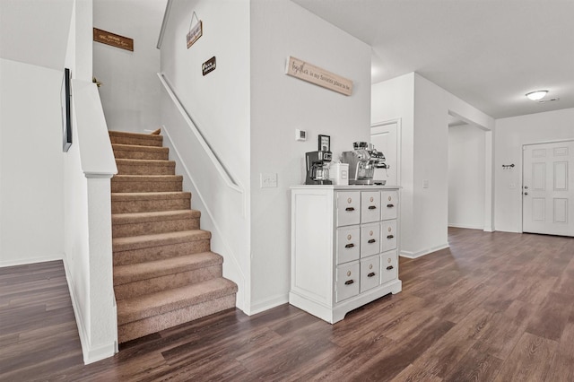 staircase featuring wood finished floors and baseboards