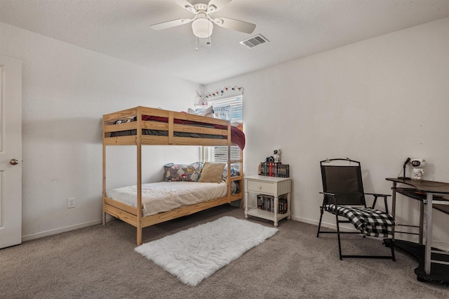 carpeted bedroom featuring a ceiling fan, visible vents, and baseboards