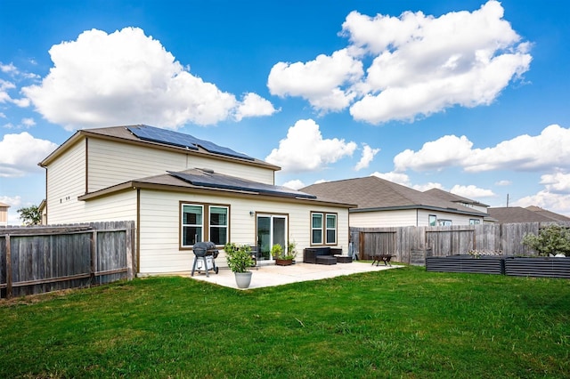 rear view of house with solar panels, a fenced backyard, a patio, and a lawn