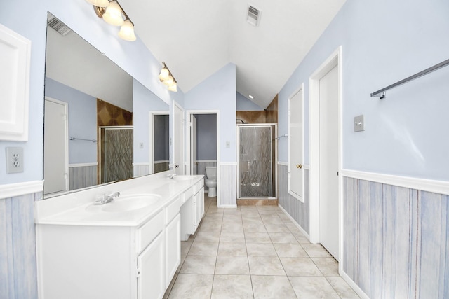 bathroom featuring toilet, a shower with door, tile patterned flooring, and vaulted ceiling