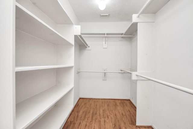 walk in closet with wood-type flooring