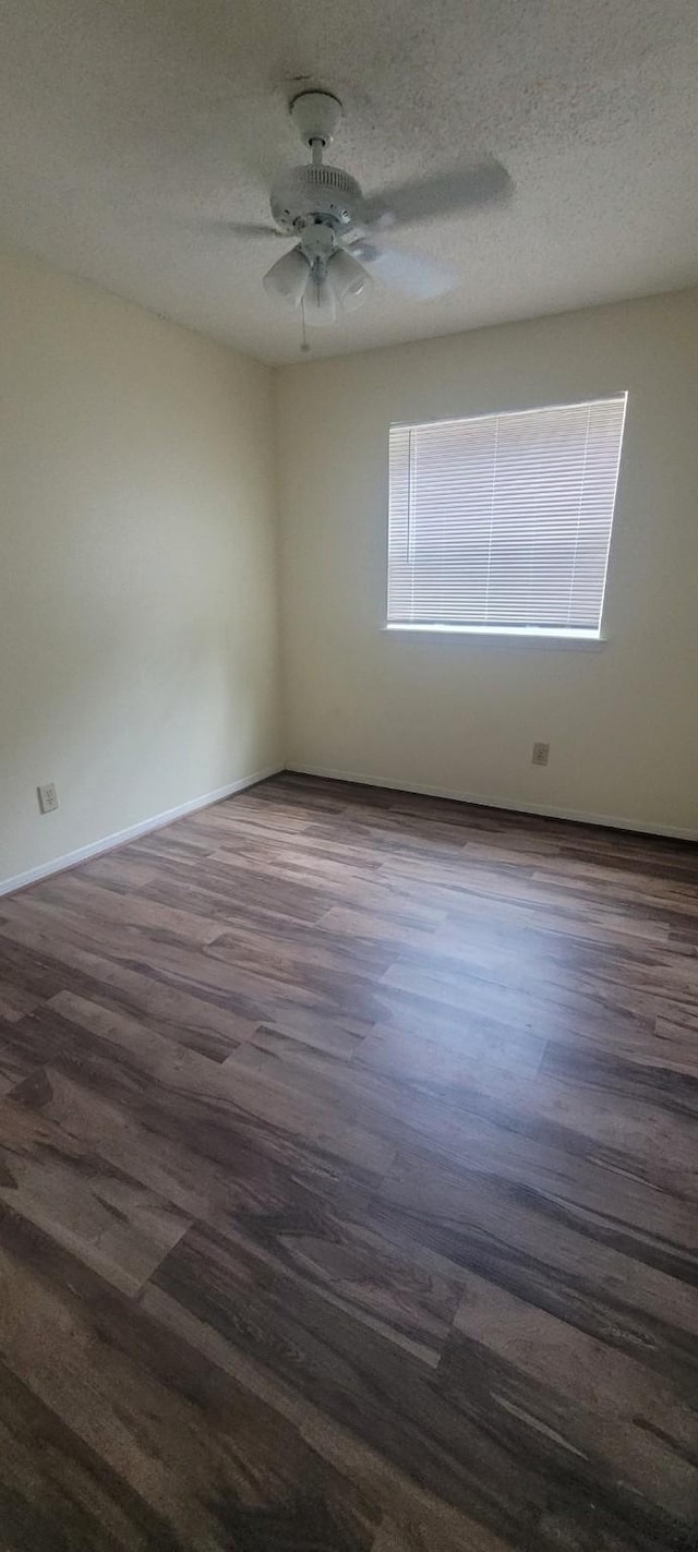 empty room featuring ceiling fan, a textured ceiling, and dark hardwood / wood-style flooring