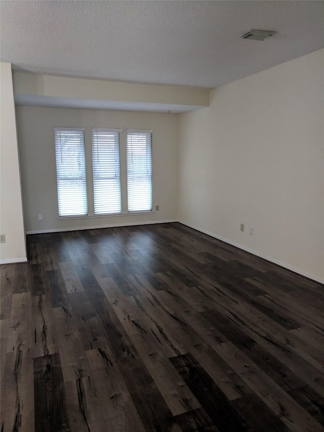 unfurnished room featuring a textured ceiling and dark hardwood / wood-style floors