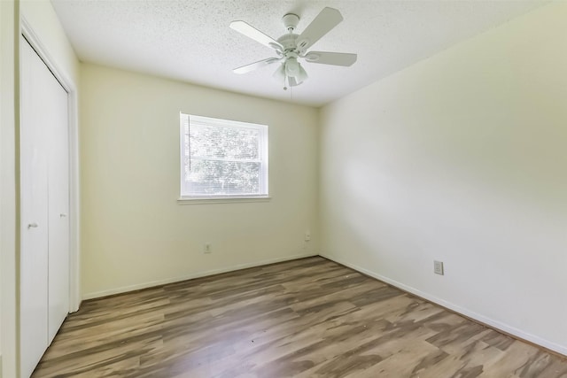 16002 Maple Acres Ct, Houston, TX 77095 - unfurnished bedroom featuring a closet, wood finished floors, a textured ceiling, and ceiling fan