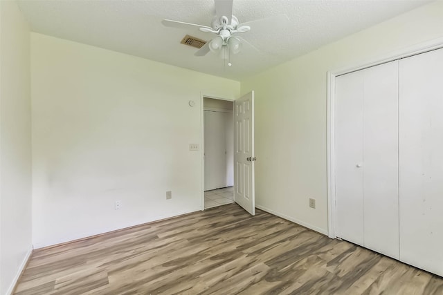 16002 Maple Acres Ct, Houston, TX 77095 - unfurnished bedroom with wood finished floors, a closet, ceiling fan, and a textured ceiling