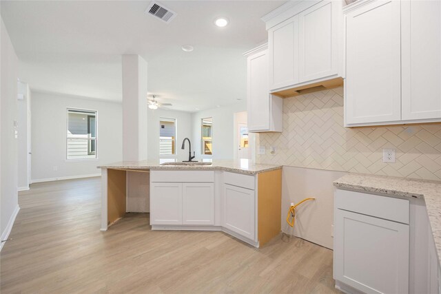 kitchen featuring sink, ceiling fan, tasteful backsplash, and white cabinetry