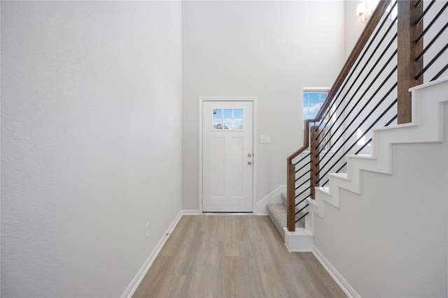 foyer entrance featuring light hardwood / wood-style floors and a high ceiling