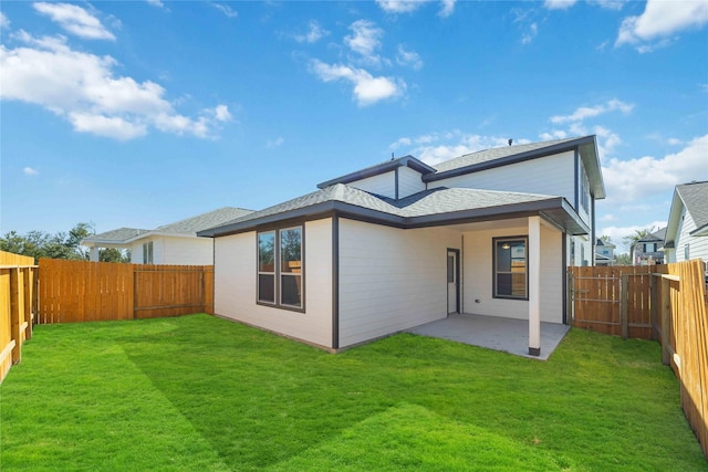 rear view of house with a lawn and a patio