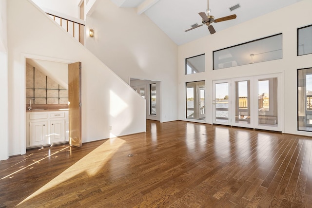 unfurnished living room featuring sink, ceiling fan, high vaulted ceiling, dark hardwood / wood-style flooring, and beam ceiling