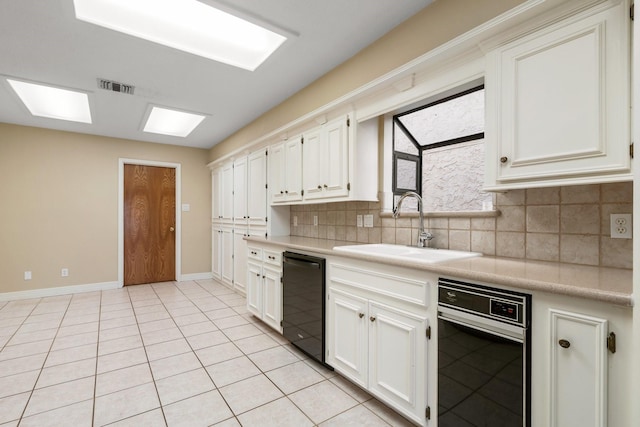 kitchen with sink, white cabinets, light tile patterned flooring, and backsplash