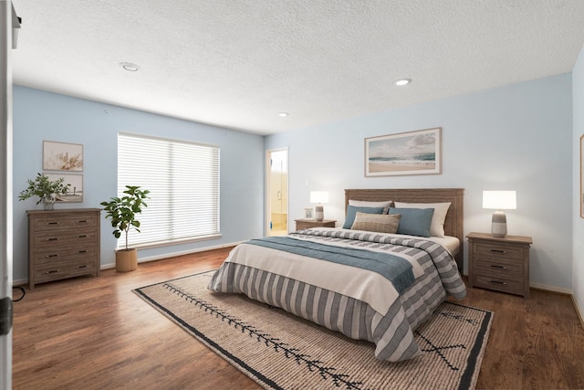 bedroom with a textured ceiling and dark hardwood / wood-style flooring