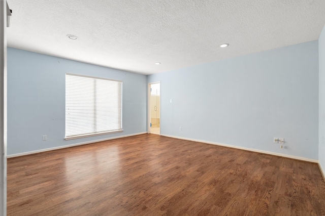 unfurnished room featuring a textured ceiling and hardwood / wood-style floors