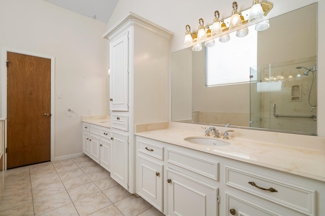 bathroom with a shower with door, vanity, and tile patterned floors