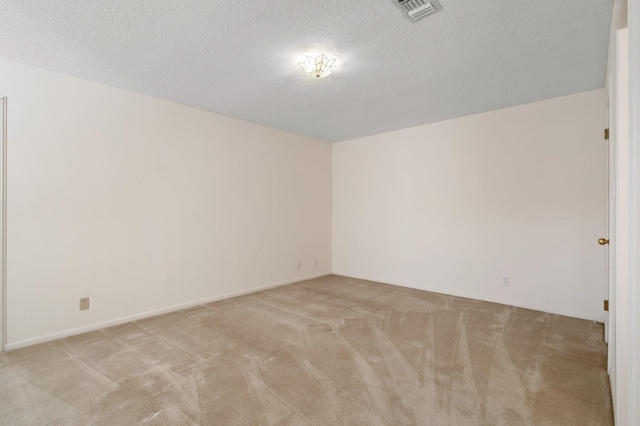 carpeted empty room featuring a textured ceiling