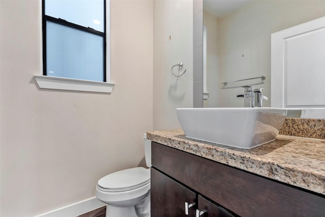 bathroom featuring toilet, wood-type flooring, and vanity