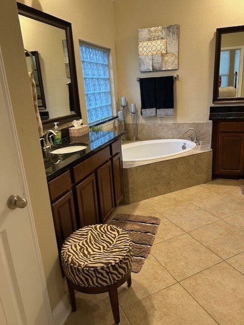 bathroom featuring vanity, tiled tub, and tile patterned floors