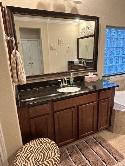 bathroom featuring vanity, crown molding, and tiled bath