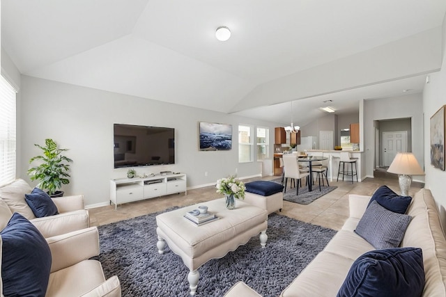 tiled living room featuring an inviting chandelier and vaulted ceiling