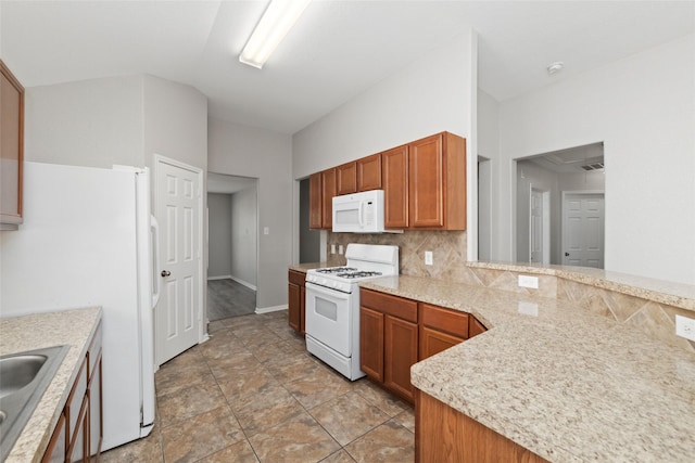 kitchen featuring white appliances, kitchen peninsula, and decorative backsplash