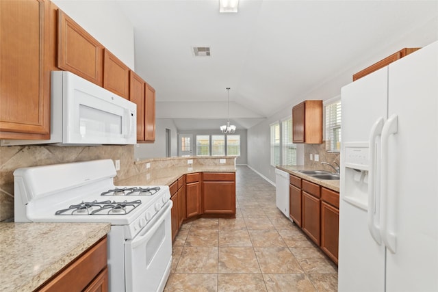 kitchen featuring white appliances, an inviting chandelier, kitchen peninsula, decorative light fixtures, and lofted ceiling