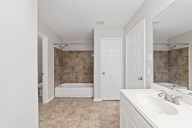 full bathroom featuring toilet, vanity, and tiled shower / bath