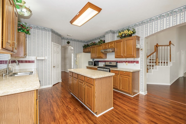 kitchen with a kitchen island, stainless steel appliances, dark wood-type flooring, and sink