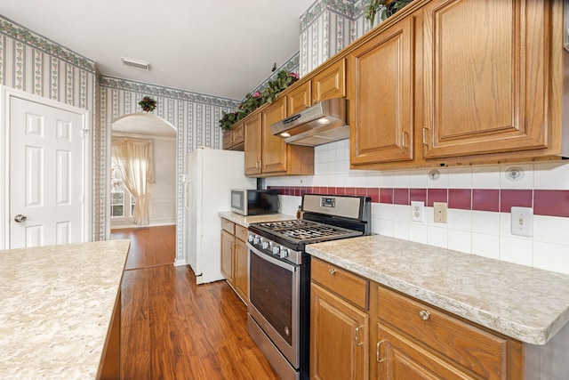 kitchen featuring appliances with stainless steel finishes and dark hardwood / wood-style flooring