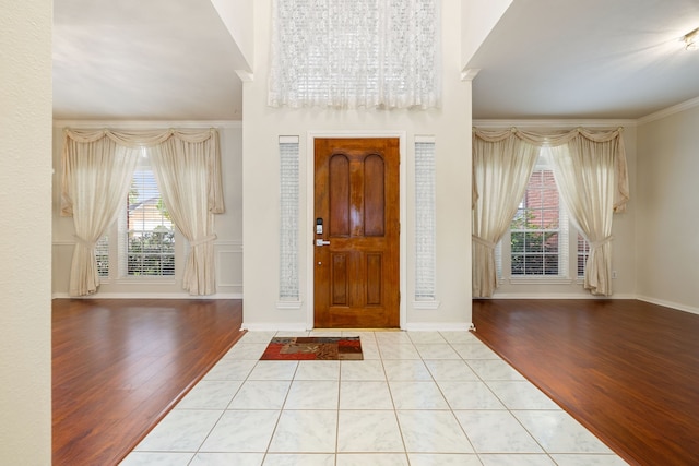 tiled foyer featuring ornamental molding