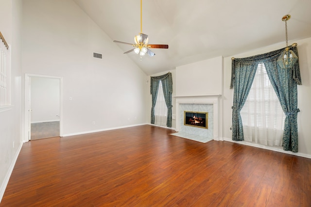 unfurnished living room featuring ceiling fan, a tile fireplace, high vaulted ceiling, and hardwood / wood-style flooring