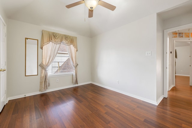 empty room with ceiling fan, dark hardwood / wood-style flooring, and lofted ceiling