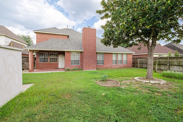 rear view of house with a patio and a lawn