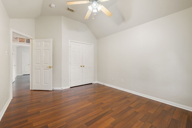 unfurnished bedroom featuring lofted ceiling, a closet, ceiling fan, and dark wood-type flooring