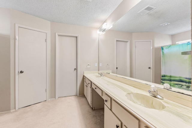 bathroom featuring a textured ceiling, walk in shower, and vanity