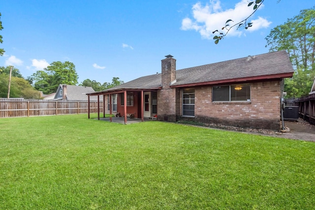 rear view of property with a lawn, central AC unit, and a patio