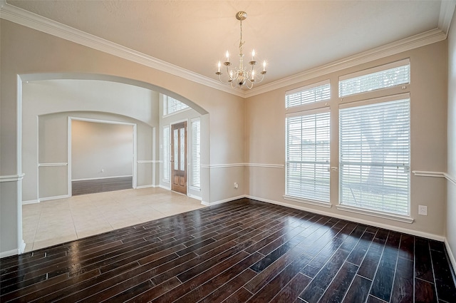 unfurnished room with ornamental molding and an inviting chandelier