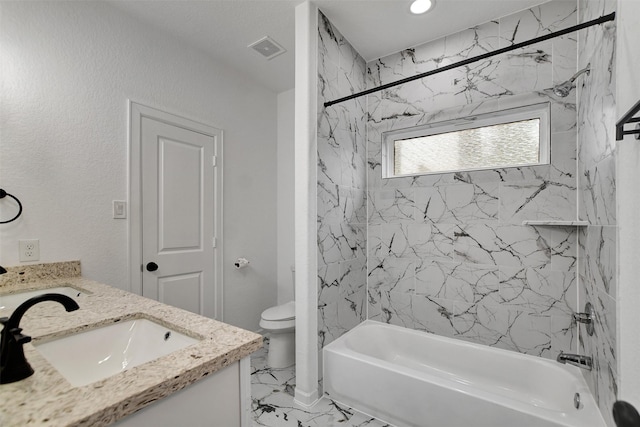 full bathroom featuring tiled shower / bath, vanity, and toilet