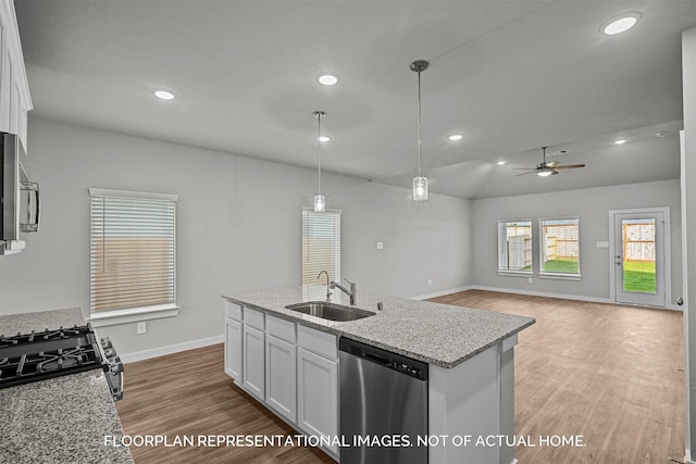 kitchen with appliances with stainless steel finishes, pendant lighting, light stone counters, sink, and white cabinetry