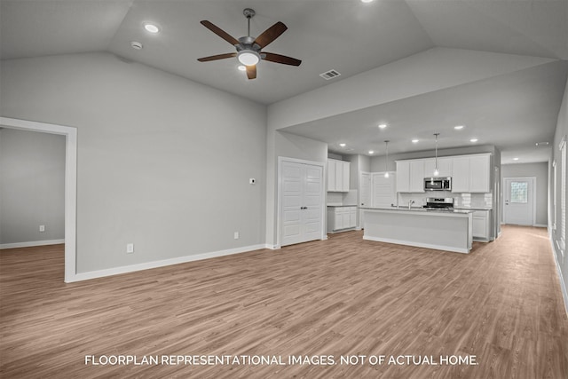 unfurnished living room with ceiling fan, light wood-type flooring, and vaulted ceiling