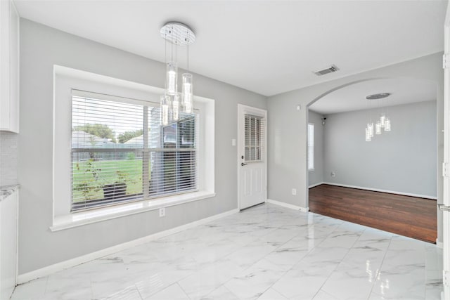 unfurnished dining area with a notable chandelier