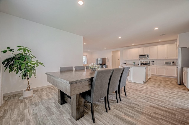 dining space with light hardwood / wood-style flooring