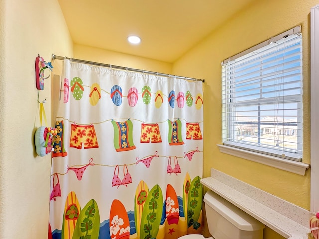 bathroom with toilet and a shower with curtain