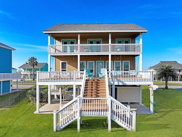 rear view of property with a patio area, a lawn, and a balcony