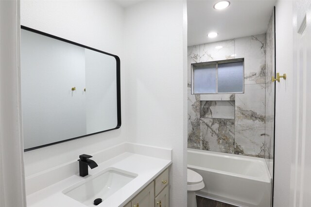 full bathroom with toilet, tiled shower / bath, and vanity