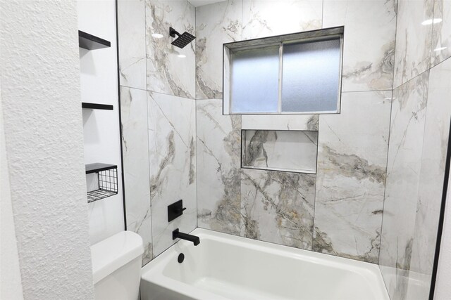 bathroom with toilet and tiled shower / bath