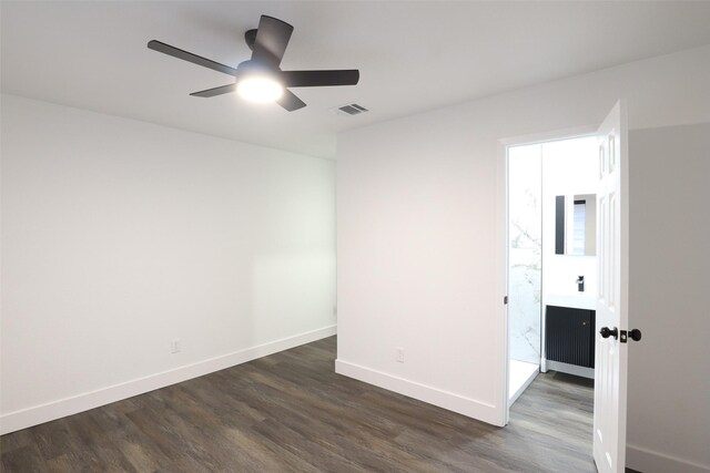 empty room with dark hardwood / wood-style flooring and ceiling fan