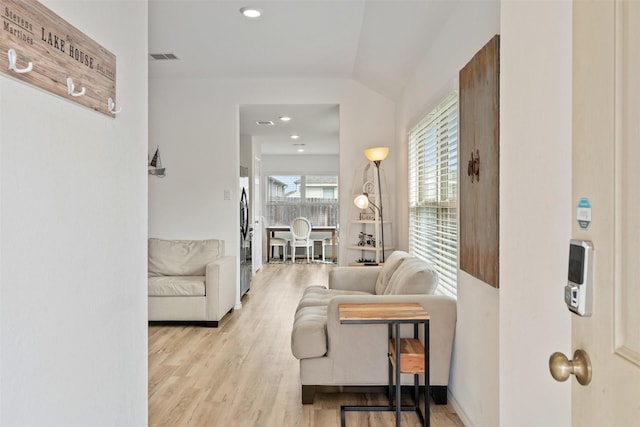 living room with vaulted ceiling and light hardwood / wood-style floors