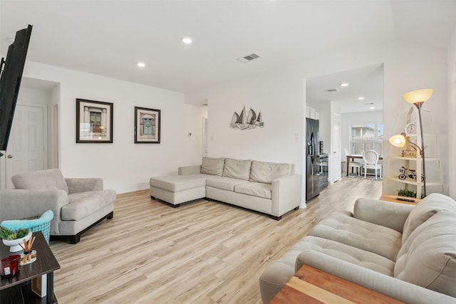 living area with light wood-style flooring, visible vents, and recessed lighting